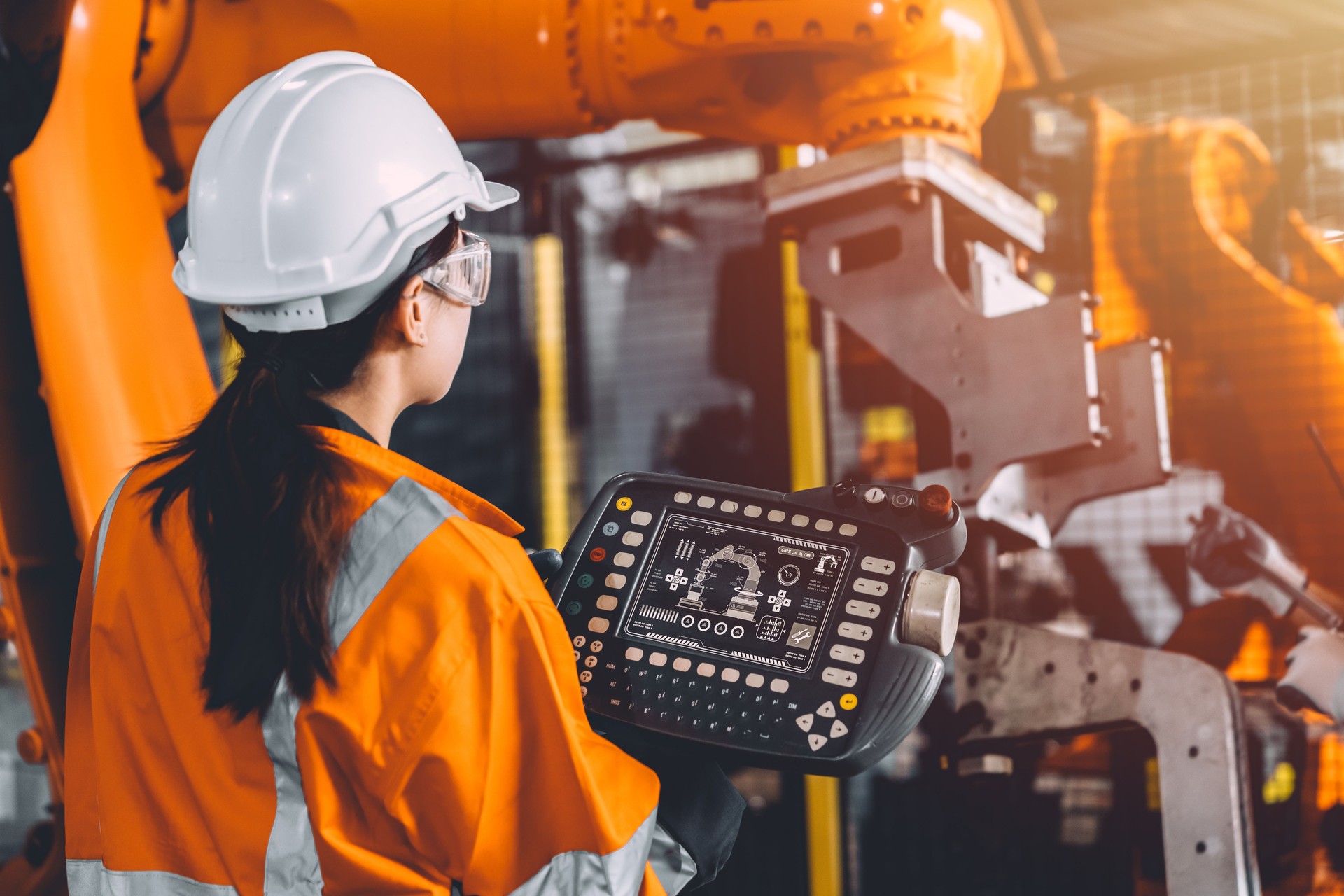 Engineer team service robot welding working in automation factory. Woman worker operate robotic arm software hand controller in automated manufacturing industry technology.